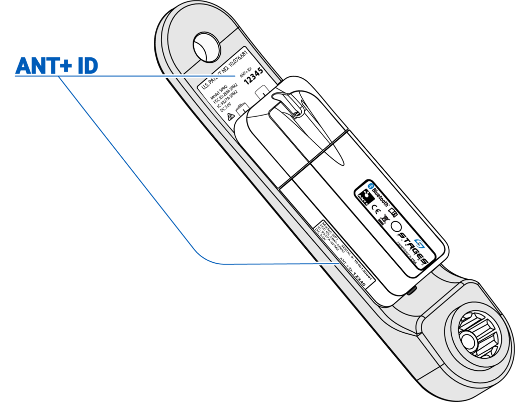 Medidor de potencia gris con funda de batería blanca y etiqueta de ID de ANT+ azul, a la izquierda con líneas que van hacia dos lugares en el brazo de la biela y la funda de la batería.